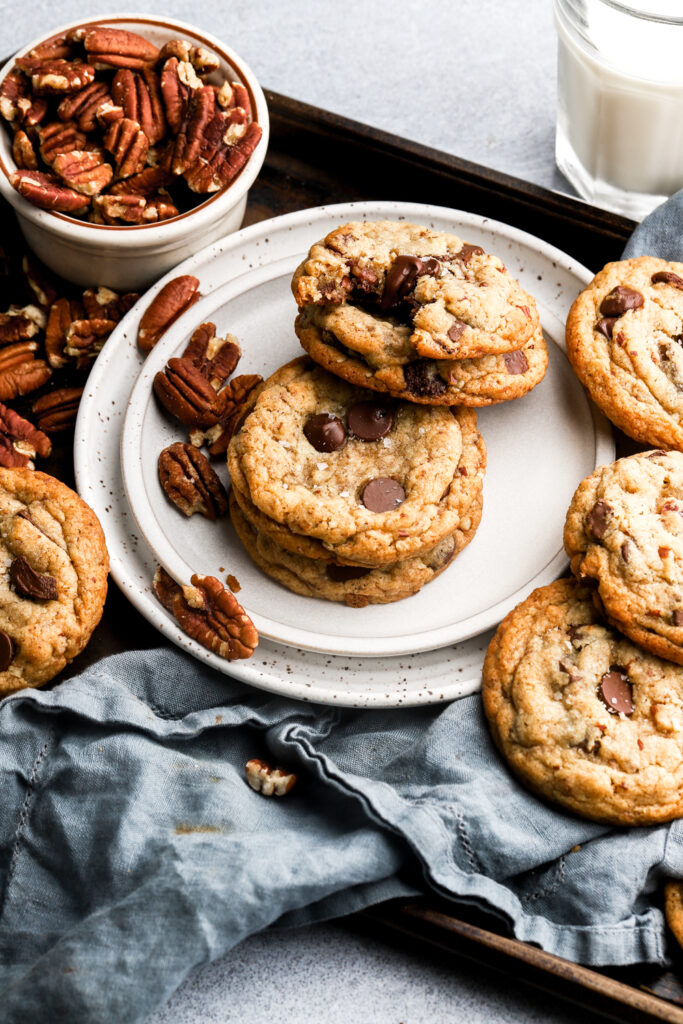 chocolate chip cookies with pecans on a plate with milk