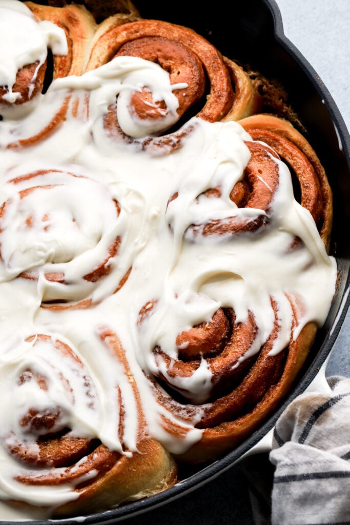 cinnamon rolls in a pan with cream cheese frosting