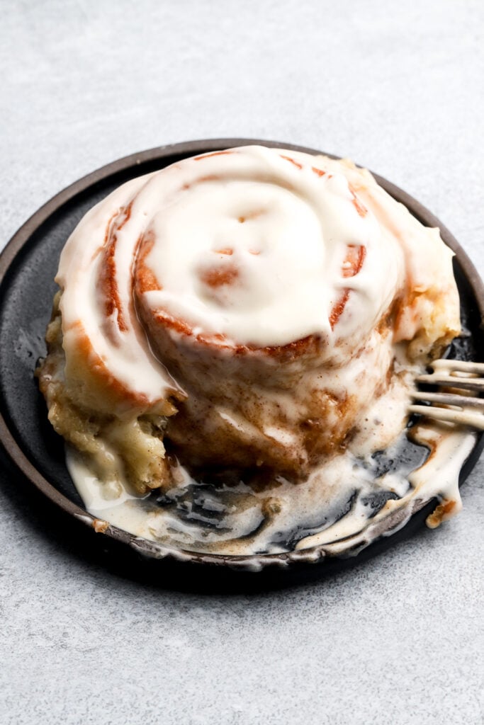 cinnamon roll in a plate with a fork