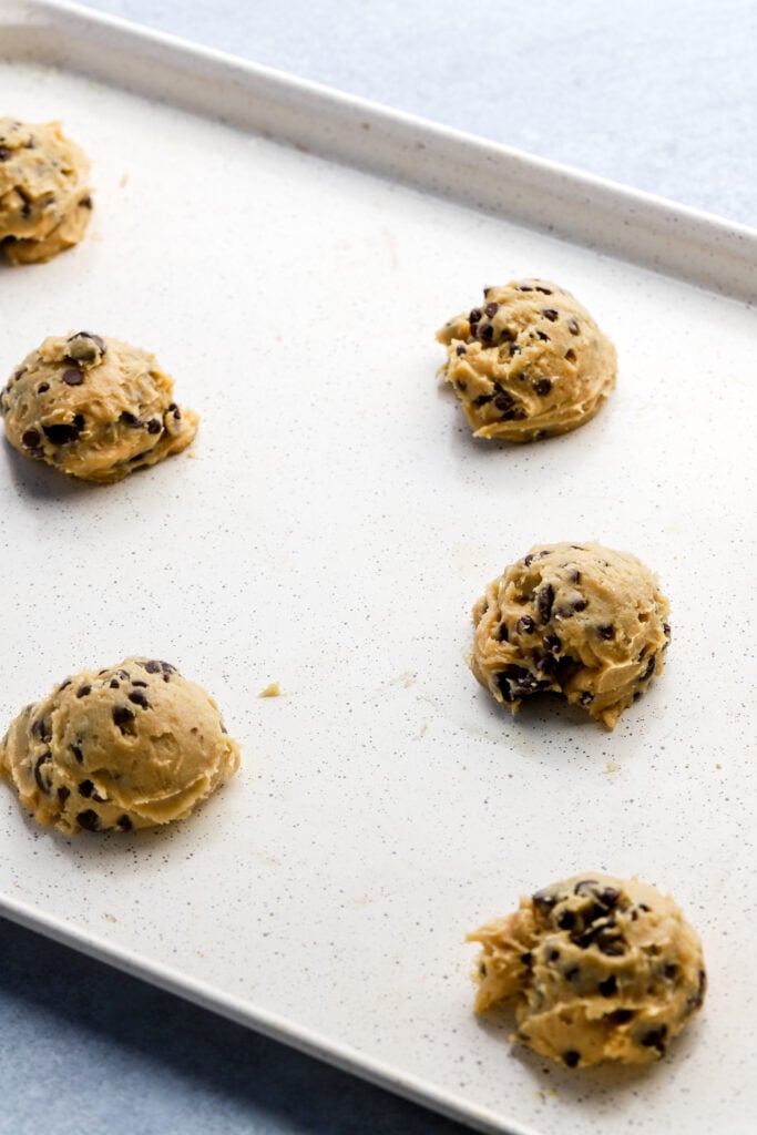 raw cookie dough scooped on a baking sheet