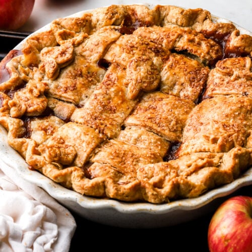 apple pie in pie dish with apples around