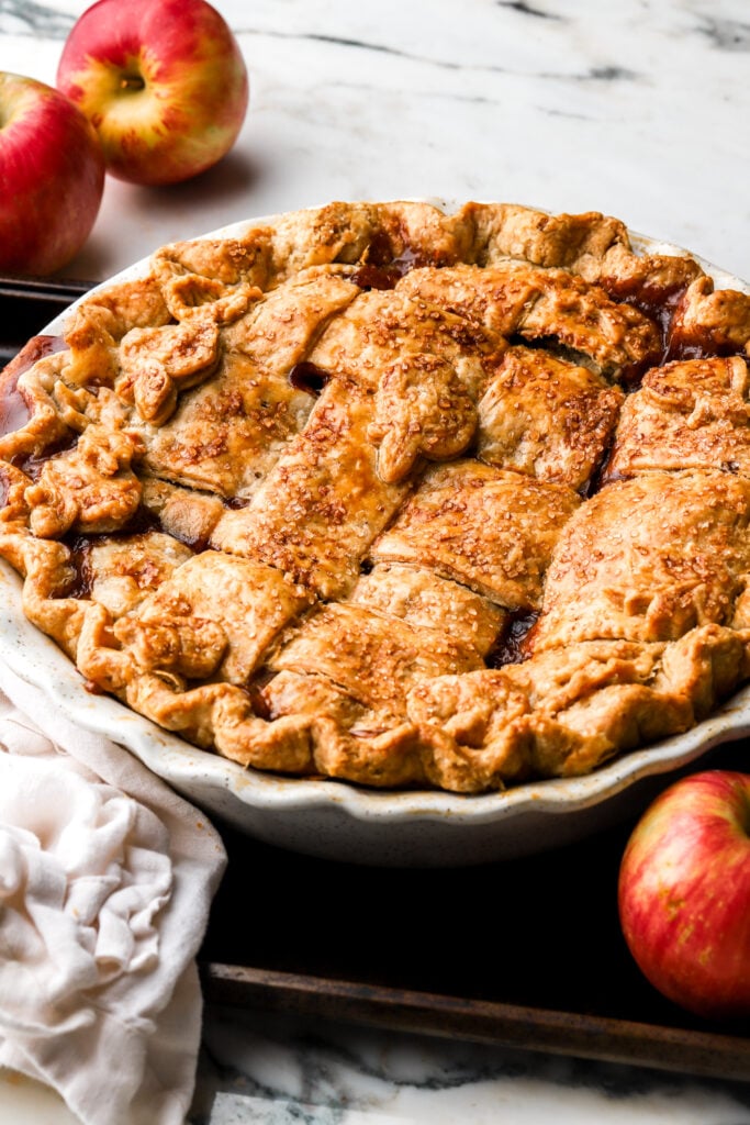 apple pie in pie dish with apples around