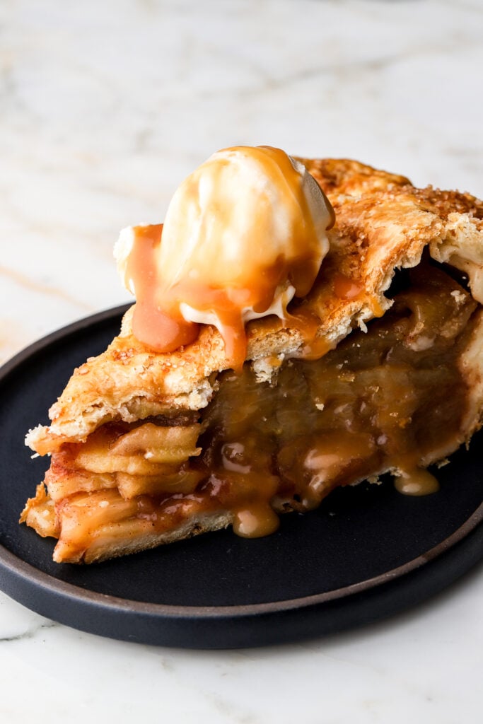 slice of apple pie with vanilla ice cream on a plate