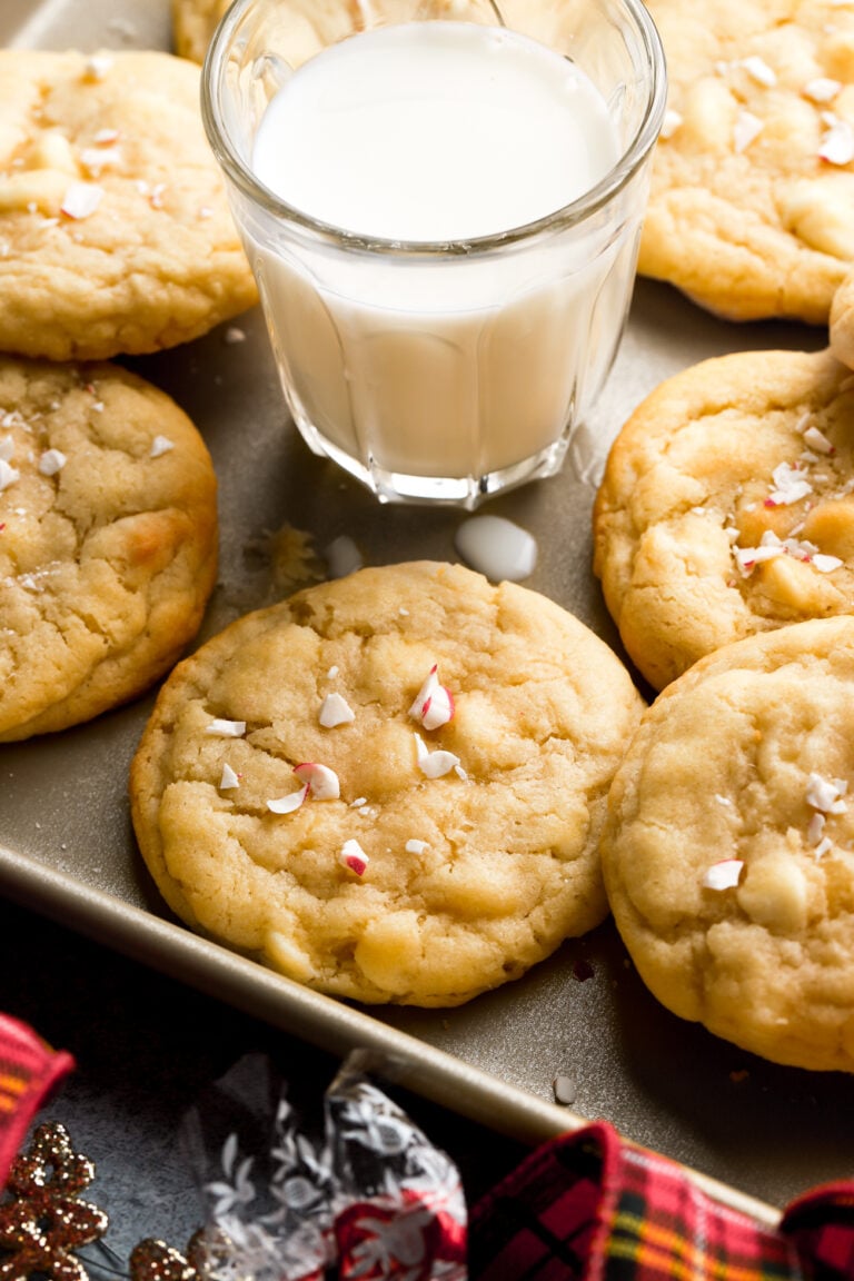 white chocolate peppermint cookies on a tray with a glass of milk