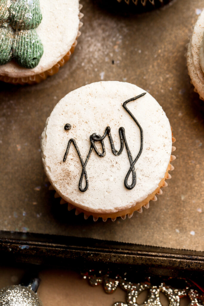 joy written on a cupcake with black frosting