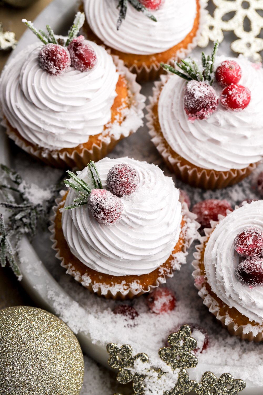 frosted cranberry cupcakes topped with sugared rosemary