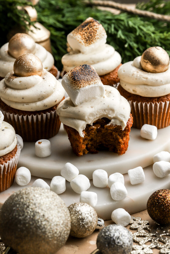 gingerbread cupcakes frosted with toasted marshmallow frosting and a bite taken out