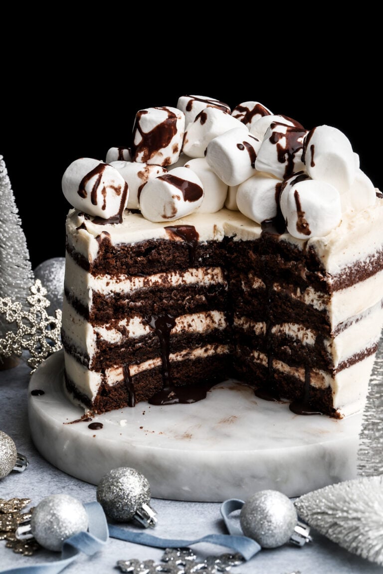 hot chocolate cake topped with marshmallows and chocolate fudge sauce with a few slices removed