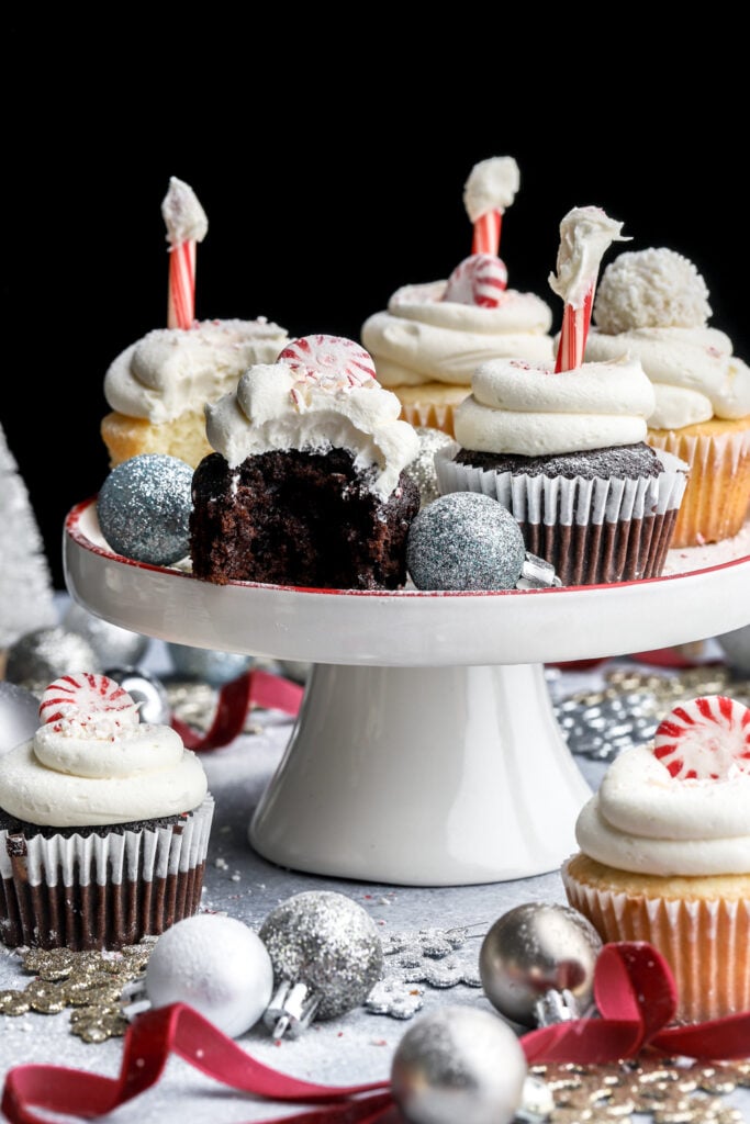 peppermint cupcakes on a small cake tray with a bite taken out of the chocolate one