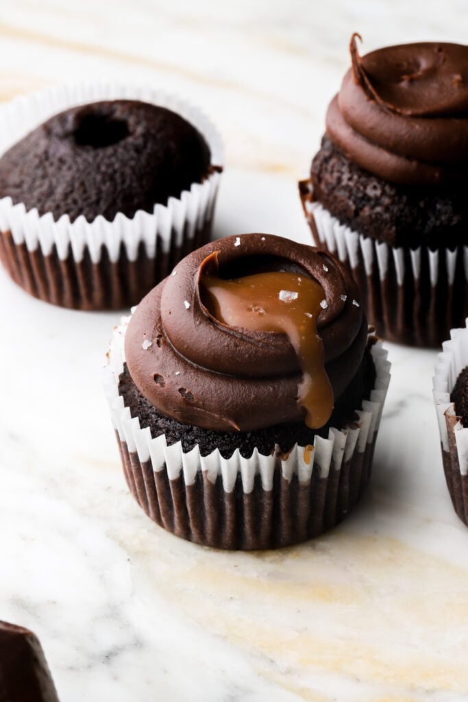 cupcakes frosted with chocolate ganache and topped with caramel sauce 