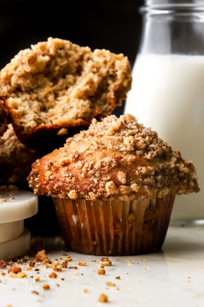 banana nut muffins with glass of milk behind