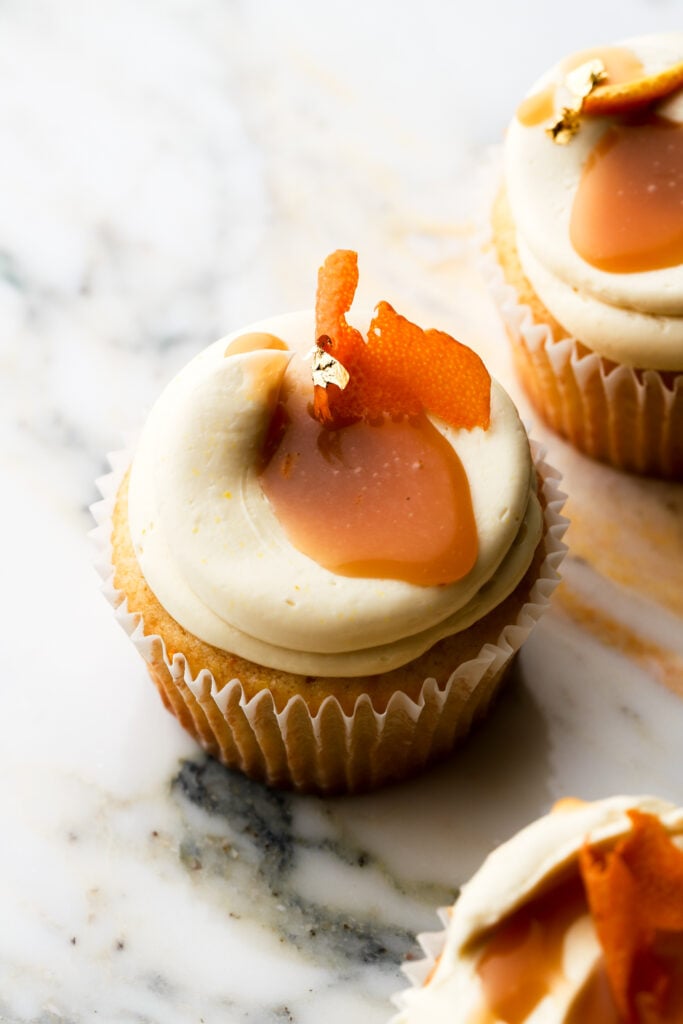 orange cupcakes topped with orange buttercream and caramel sauce