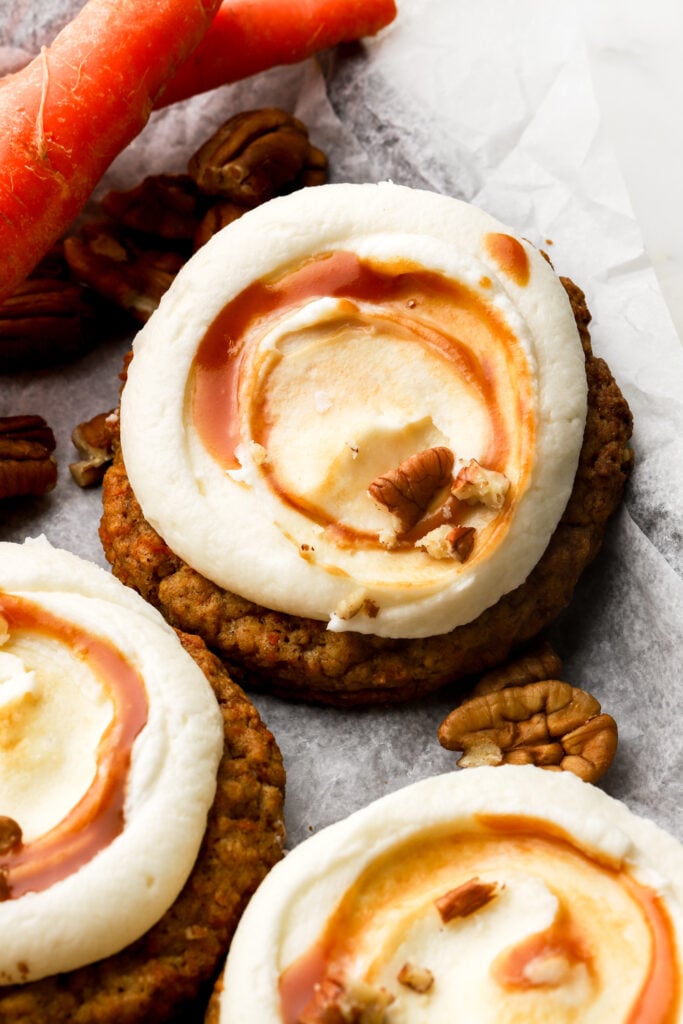 carrot cake cookies frosted with cream cheese frosting and caramel sauce