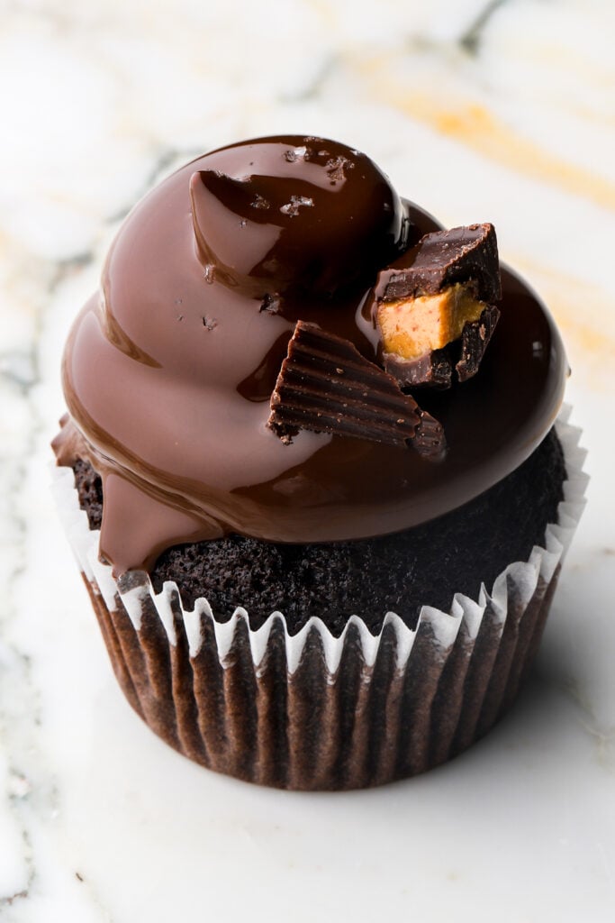 close up of a Reese's peanut butter cupcake freshly dipped in chocolate