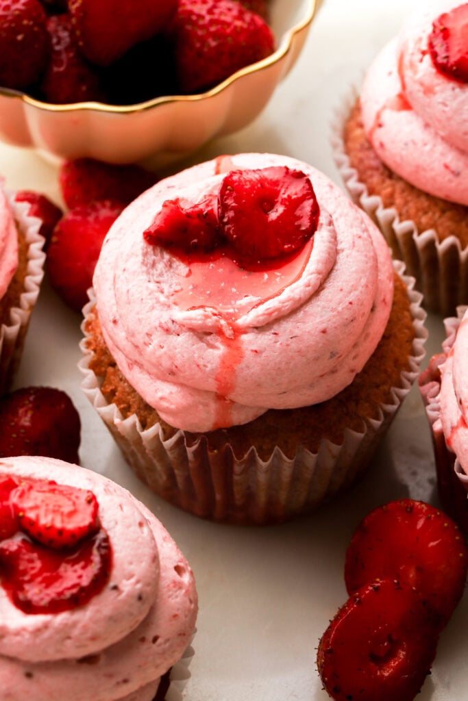 close up of strawberry cupcakes topped with strawberry slices