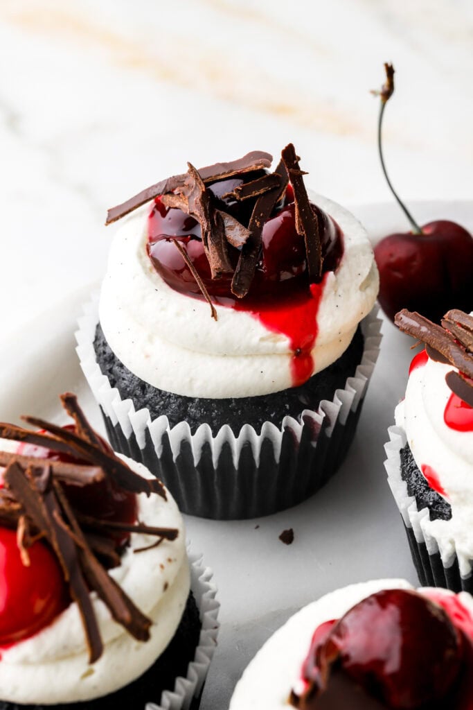 black forest cupcakes topped with cherry topping and chocolate shards