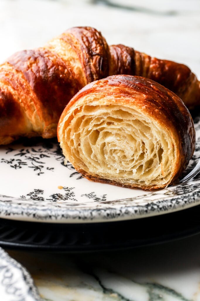 croissant cut in half to show inside, on a plate