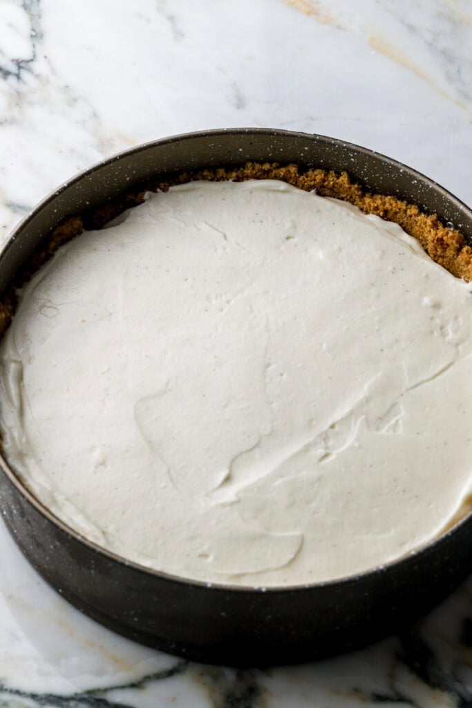 cheesecake filling spread on top of chocolate in the pan