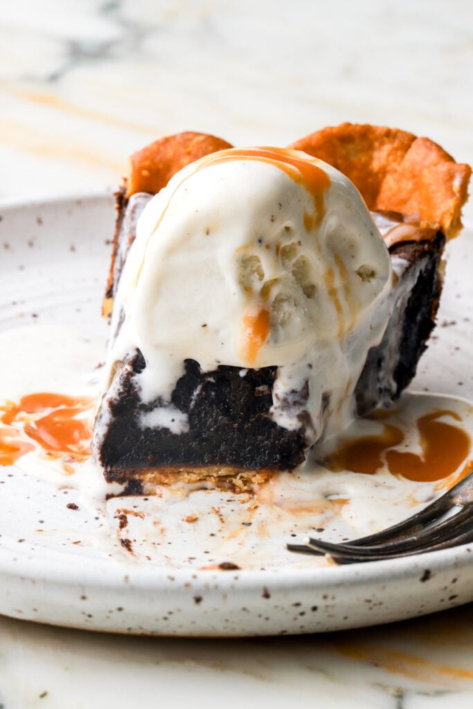 close up of a slice of brownie pie with ice cream