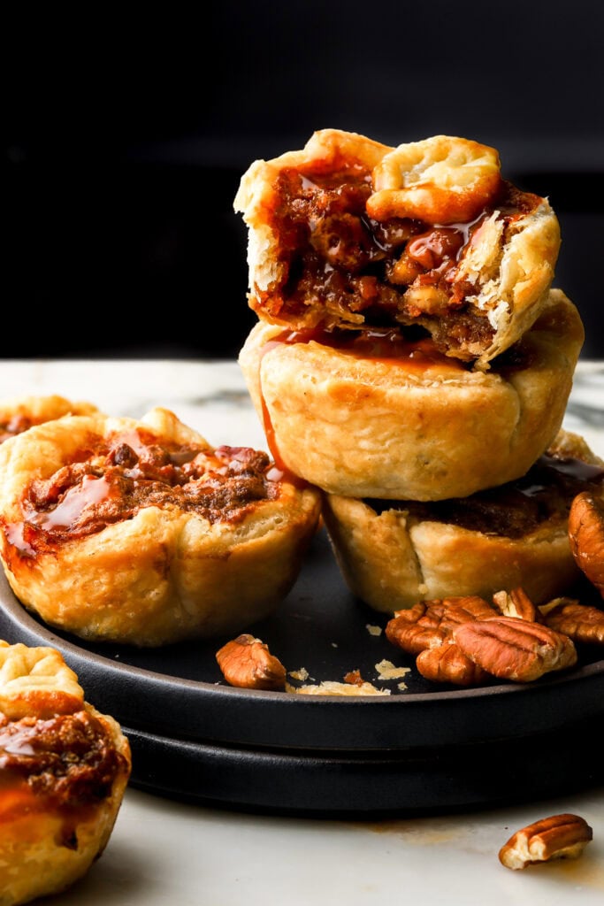 mini pecan pies stacked in a plate