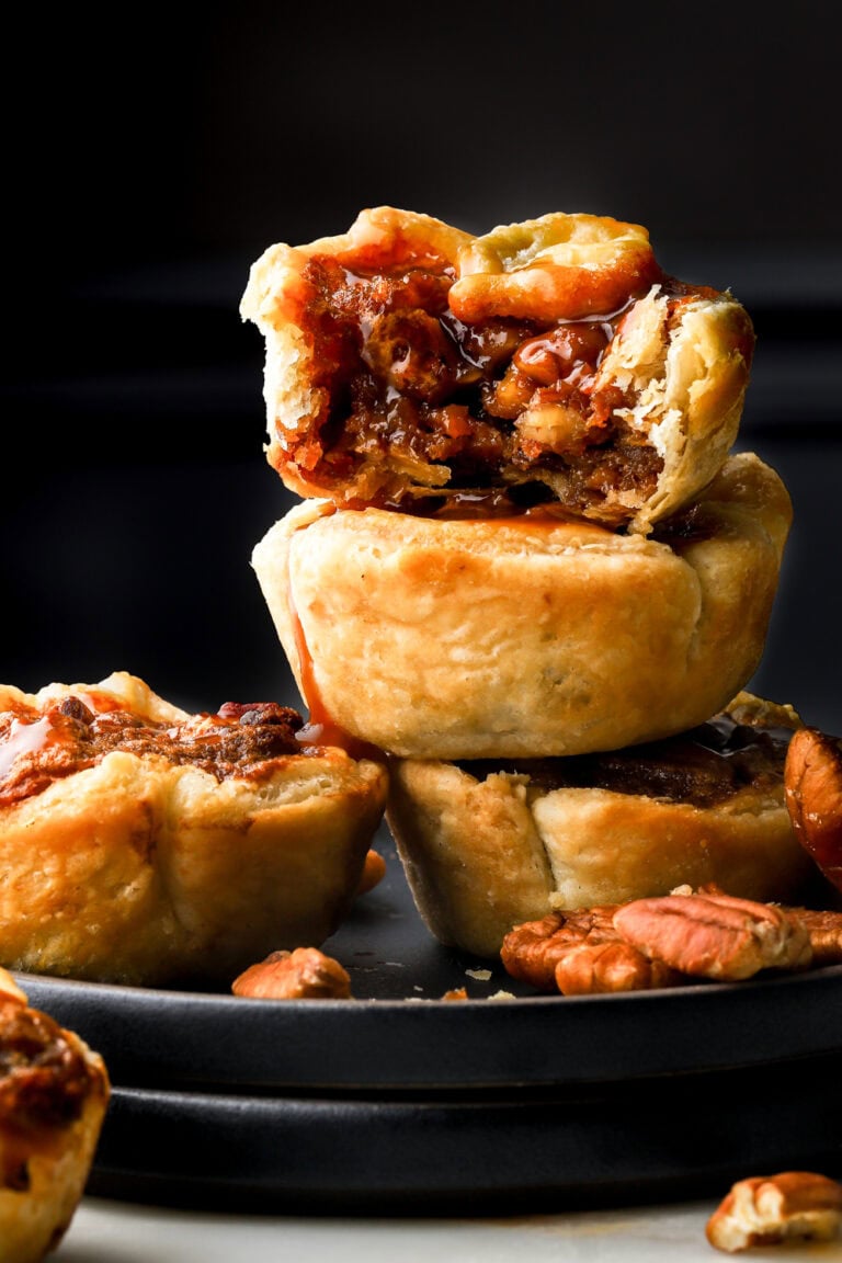 mini pecan pies stacked in a plate