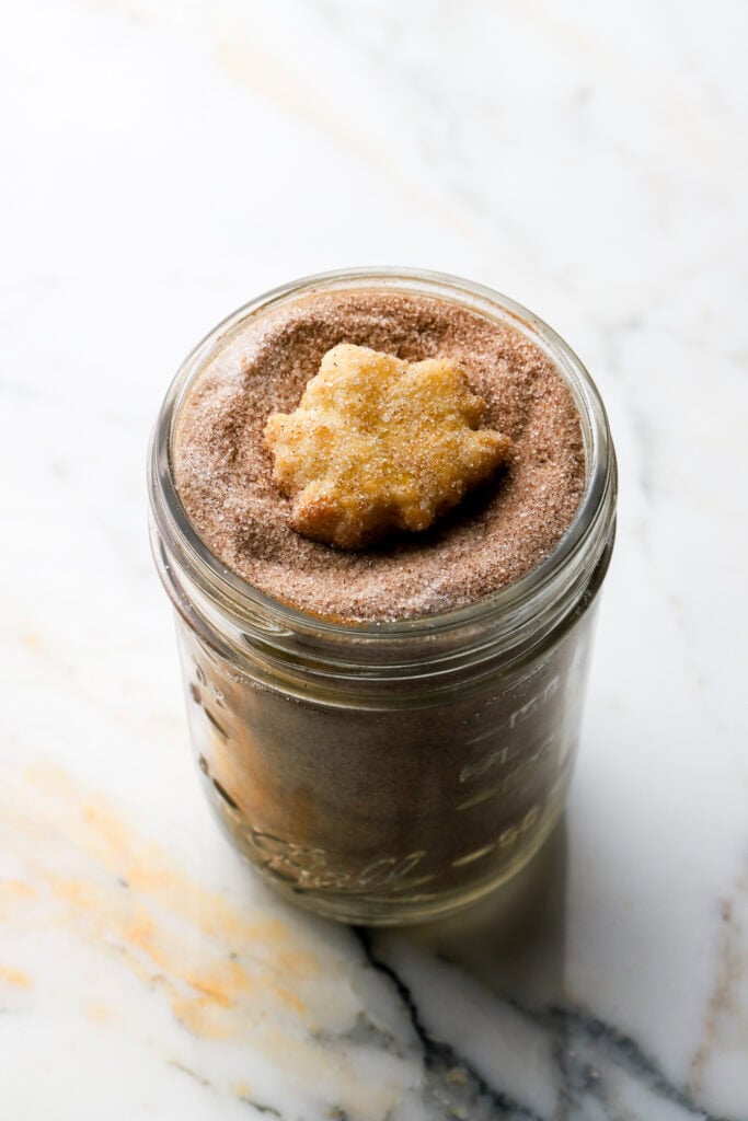 leaf shaped pie crust cookie rolled in cinnamon sugar