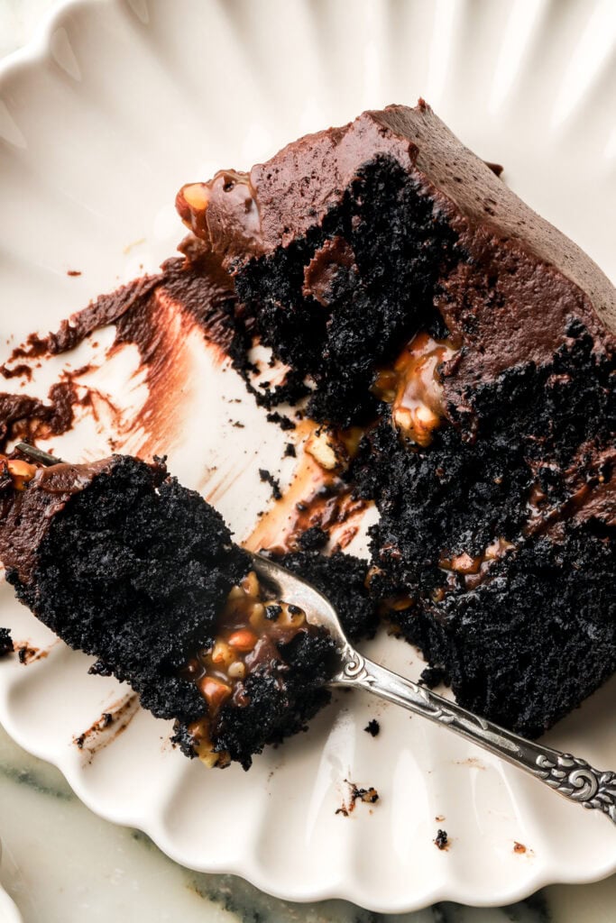 slice of chocolate turtle cake with a piece on a fork