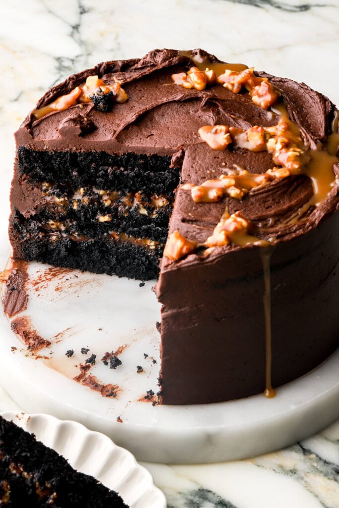 chocolate turtle cake with a couple slices cut out