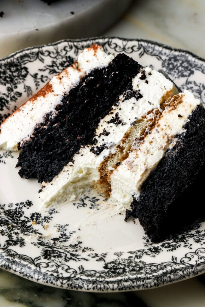 slice of chocolate tiramisu cake on a plate with a bite taken out