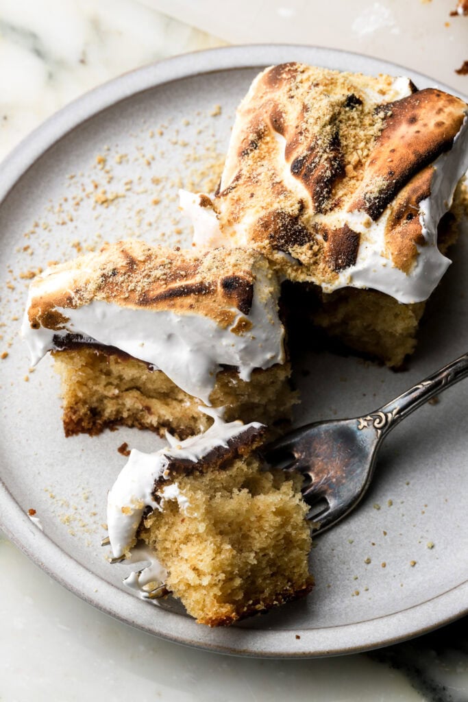 slice of s'mores sheet cake on a plate with a bite taken out