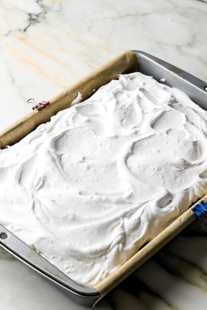 meringue spread on top of chocolate, on top of cake