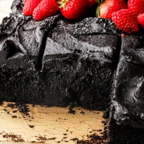 black cocoa sheet cake sliced and topped with fruit