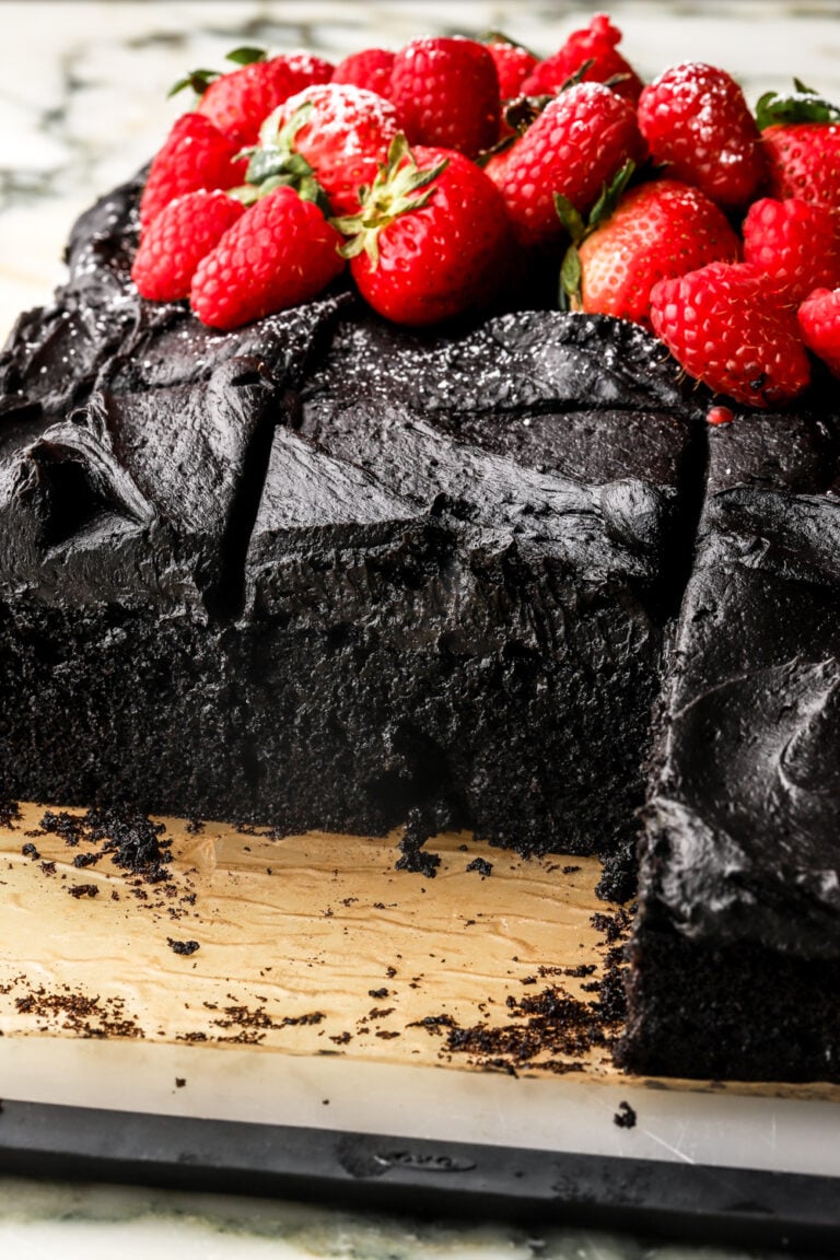 black cocoa sheet cake sliced and topped with fruit