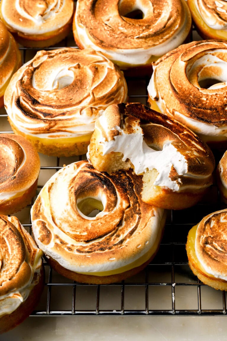 lemon meringue donuts on a tray and a bite taken out