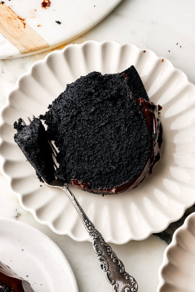 close up of a slice of black cocoa bundt cake on a plate