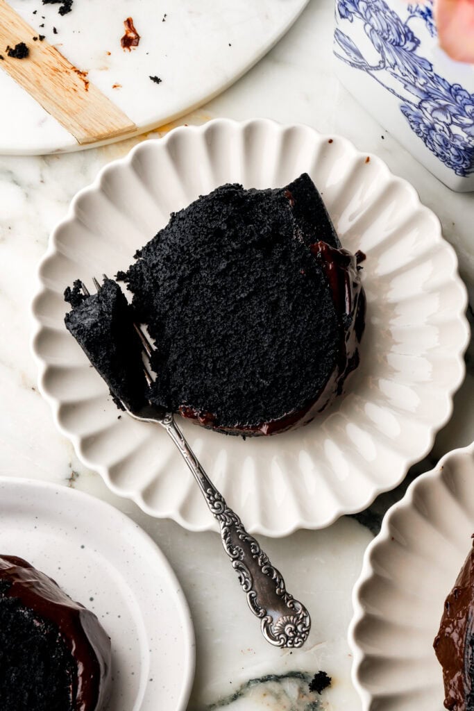 close up of a slice of black cocoa bundt cake on a plate