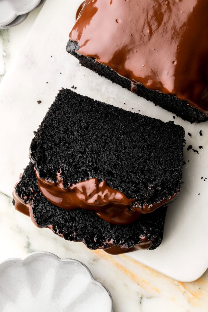 slice of black cocoa loaf cake with chocolate ganache