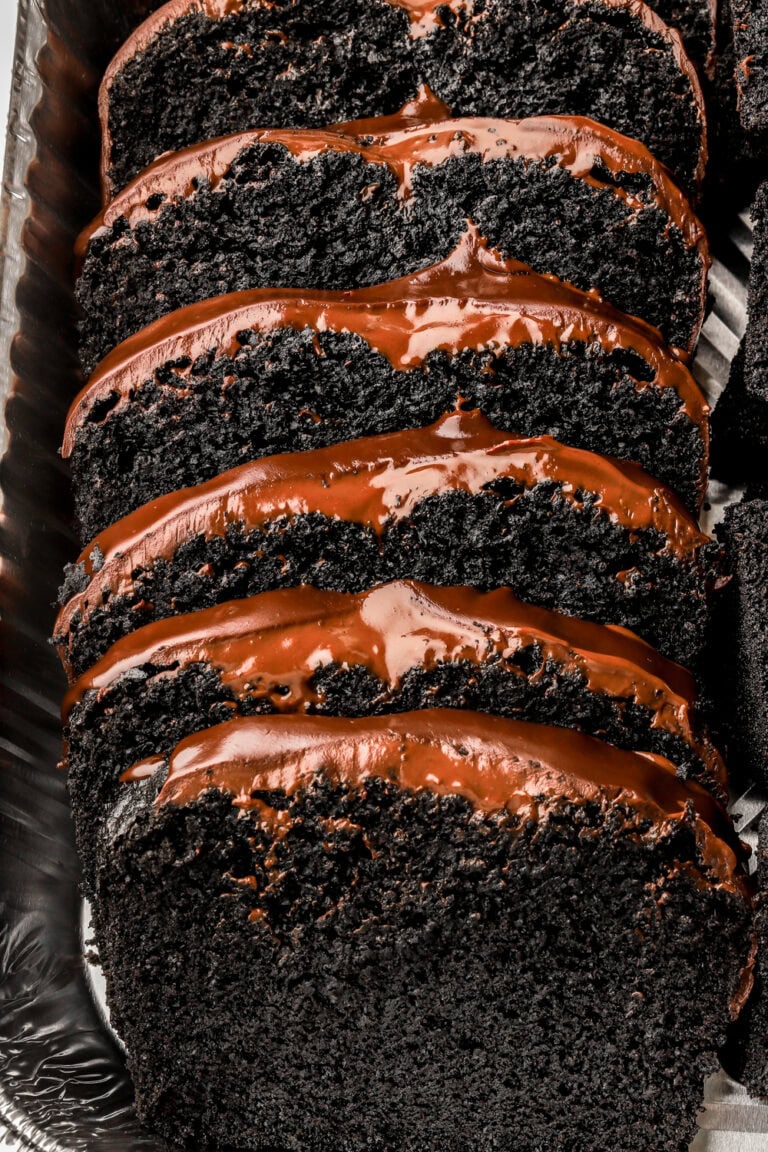 black cocoa loaf cake with chocolate ganache sliced in a pan
