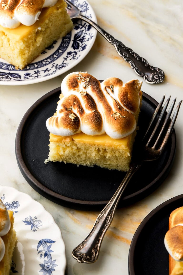slice of lemon meringue cake on a plate with a fork