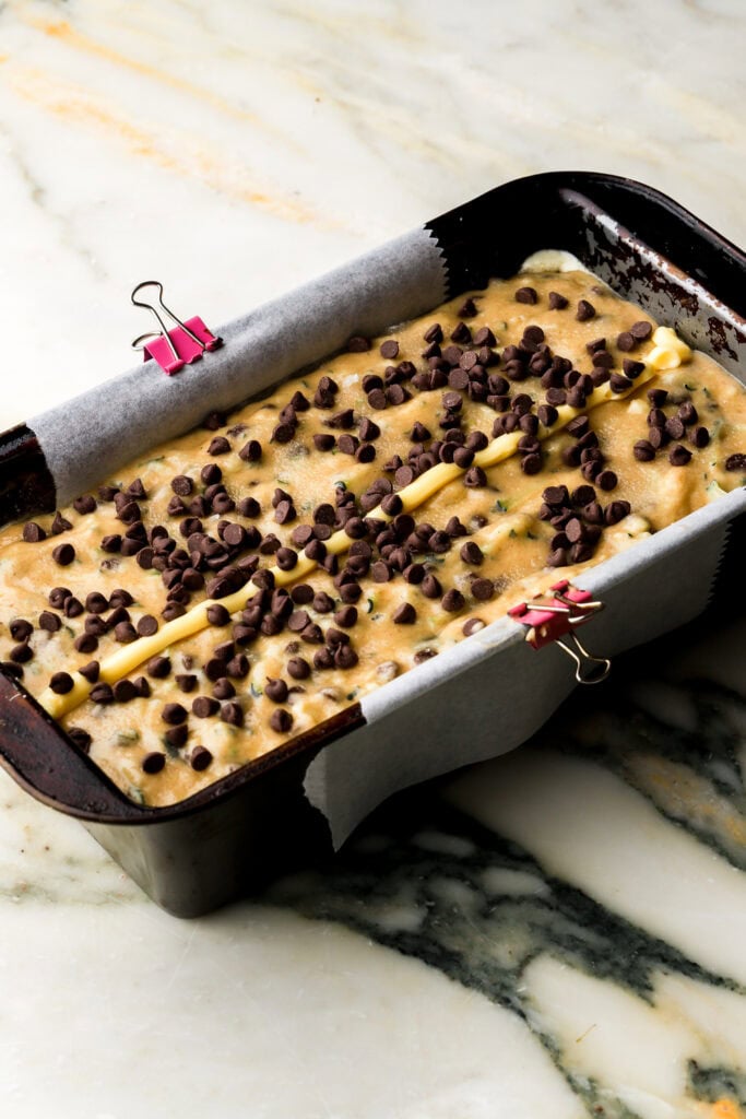 batter spread into prepared pan and topped with chocolate chips and a line of butter