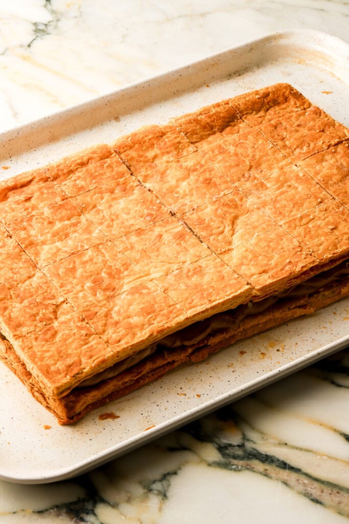 scored top layer of puff pastry place on top of chocolate cream