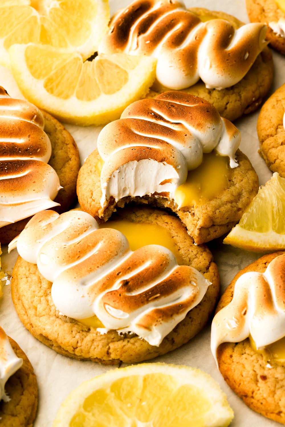 lemon meringue cookies with a bite taken out and lemon slices