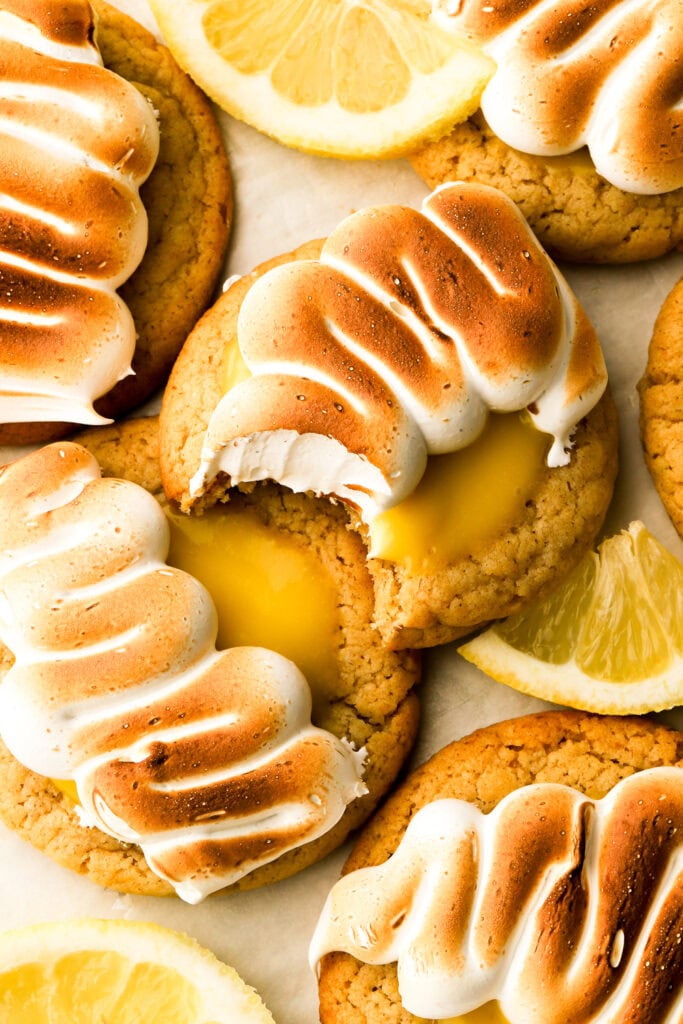 lemon meringue cookies with a bite taken out and lemon slices