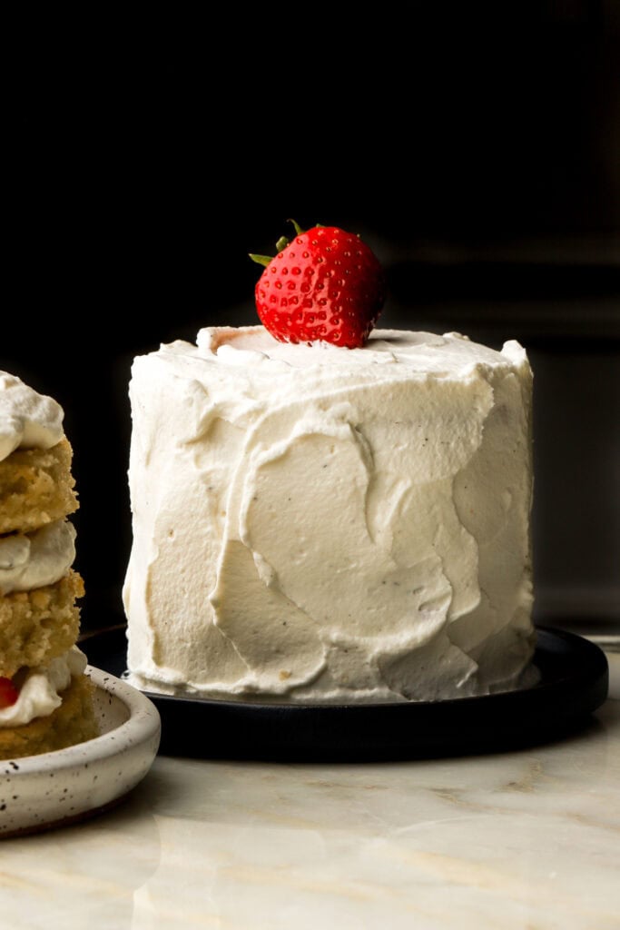 mini vanilla cake frosted with cream and a strawberry on top