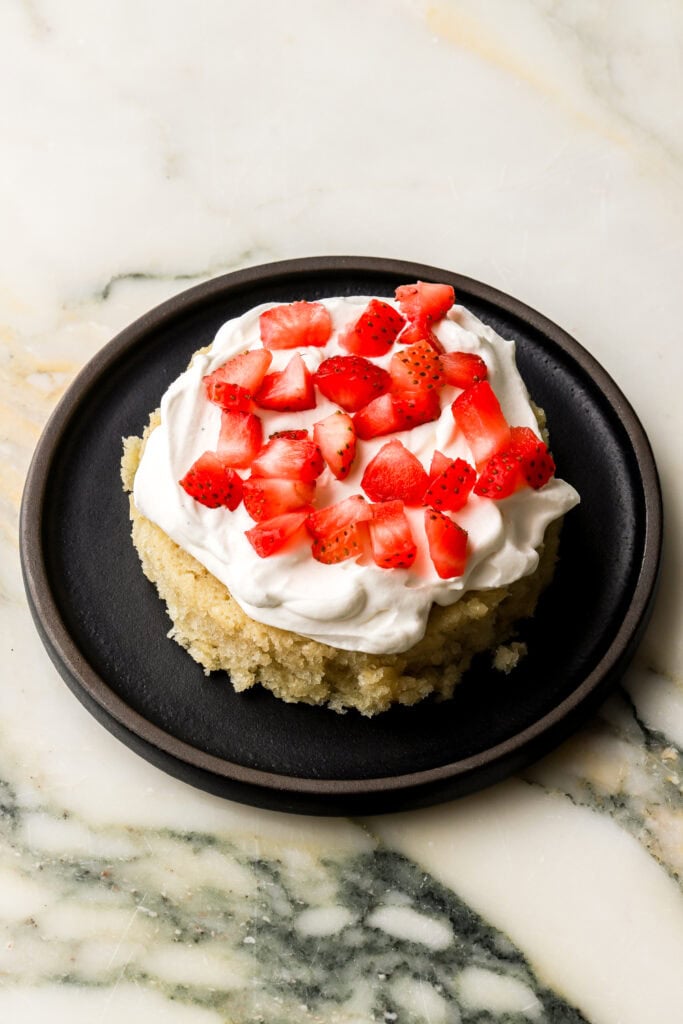 chantilly cream and strawberry chunks on top of first layer of cake