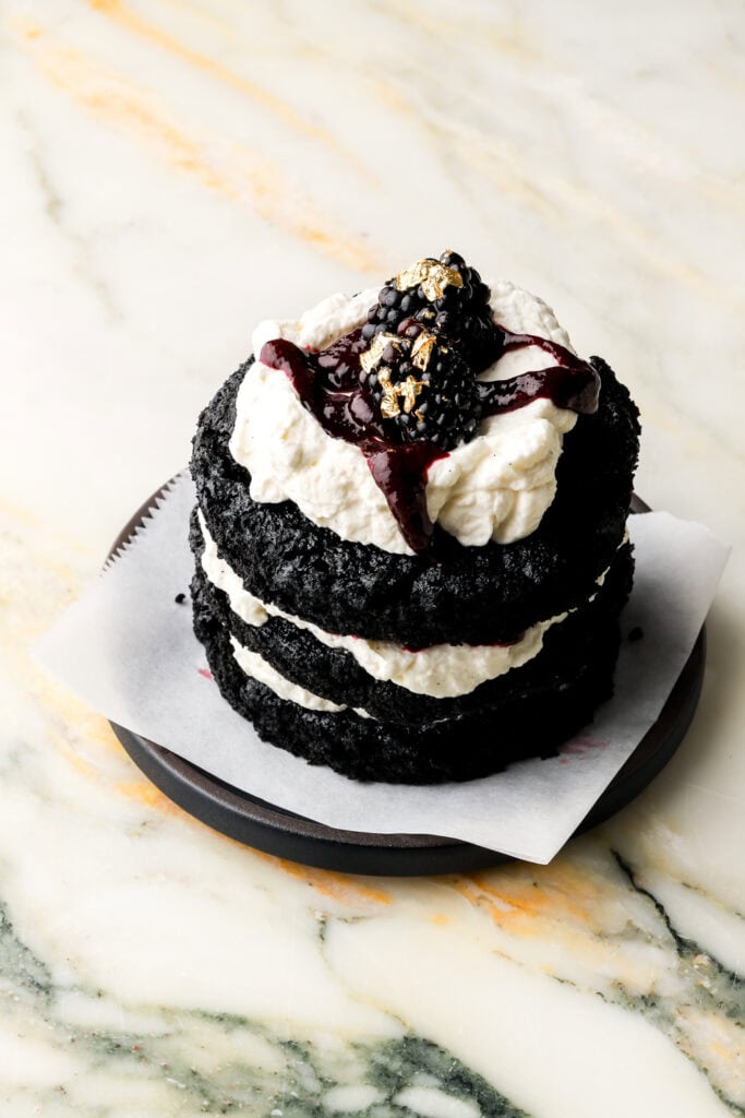 mini chocolate cake with mascarpone cream and a blackberry on top