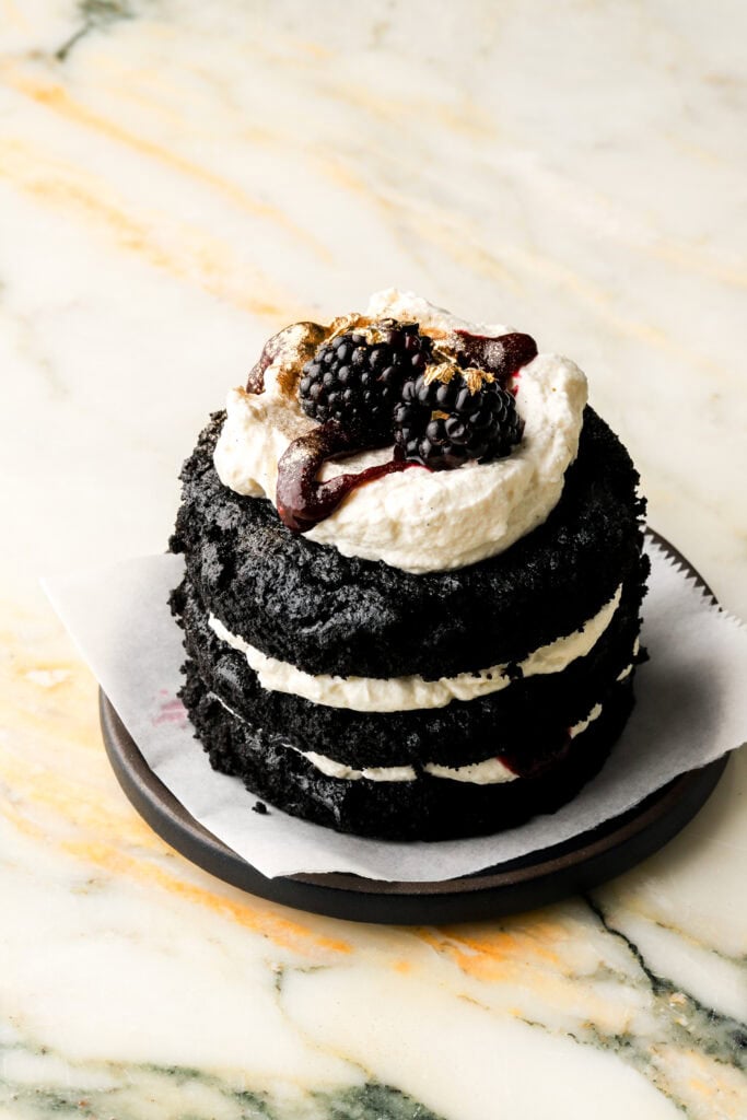 mini chocolate cake with mascarpone cream and a blackberry on top