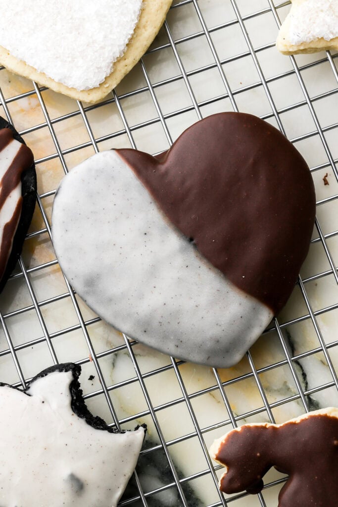 black cocoa cut out cookie in the shape of a heart and frosted with black and white icing.