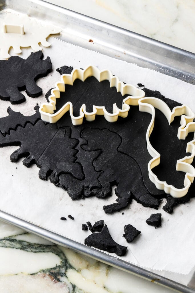 cookie dough cut into dinosaur shapes