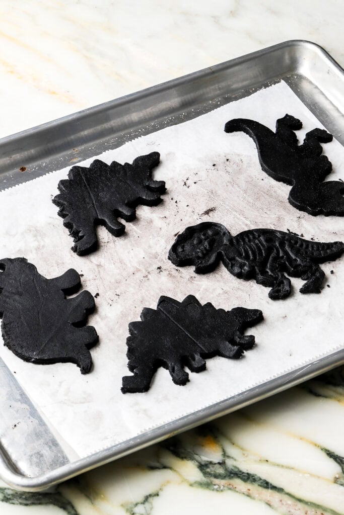 dinosaur cookies chilling on pan